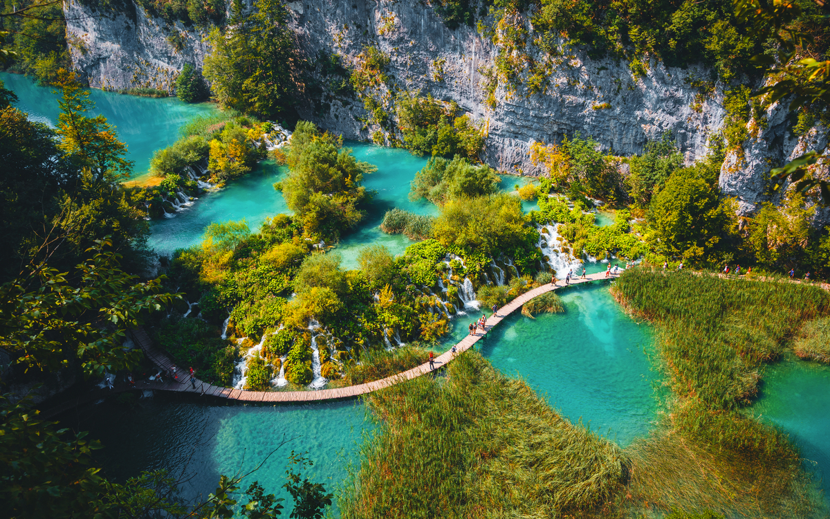 Luftaufnahme eines hölzernen Wanderwegs neben Wasserfällen im Nationalpark Plitvicer Seen - © Leonid Tit - stock.adobe.com
