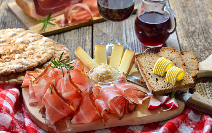 Südtiroler Bauernspeck mit Kren und reifem Bergkäse, dazu Landbrot sowie Rotwein - © kab-vision - stock.adobe.com