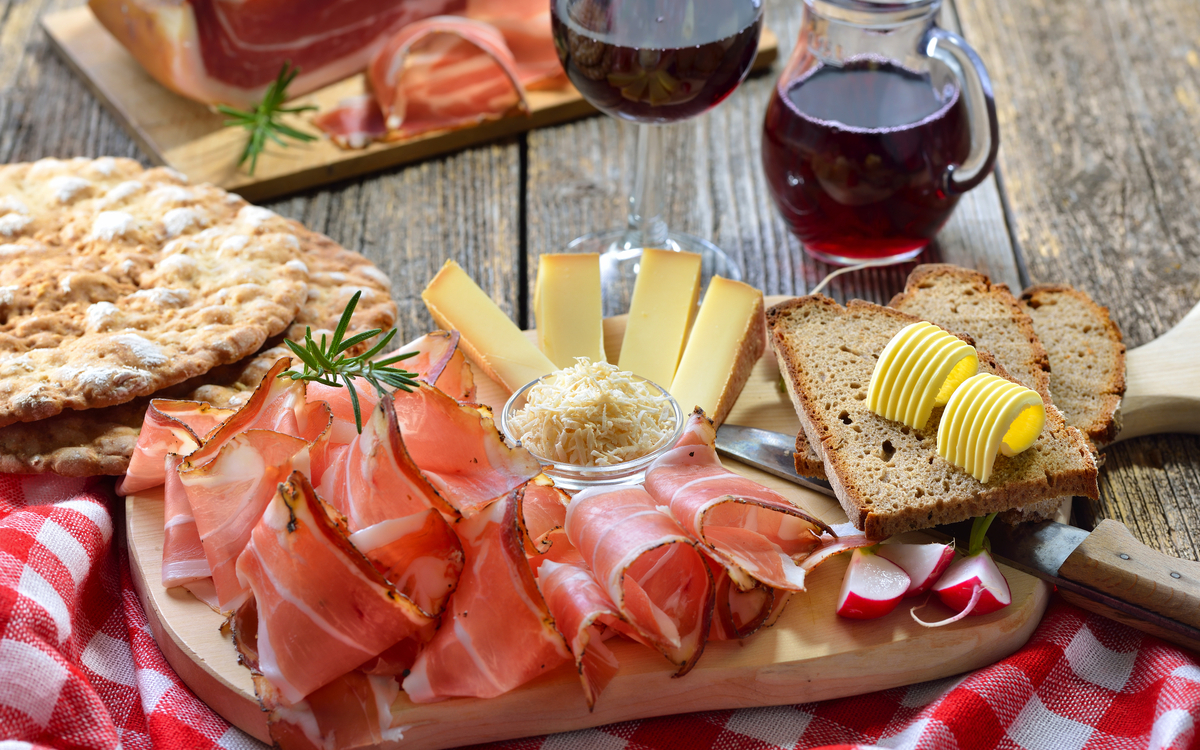 Südtiroler Bauernspeck mit Kren und reifem Bergkäse, dazu Landbrot sowie Rotwein - © kab-vision - stock.adobe.com