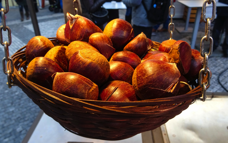 kleiner Korb mit gerösteten Kastanien, die auf dem traditionellen Weihnachtsmarkt auf dem Altstädter Ring verkauft werden, Prag - © Kamila - stock.adobe.com