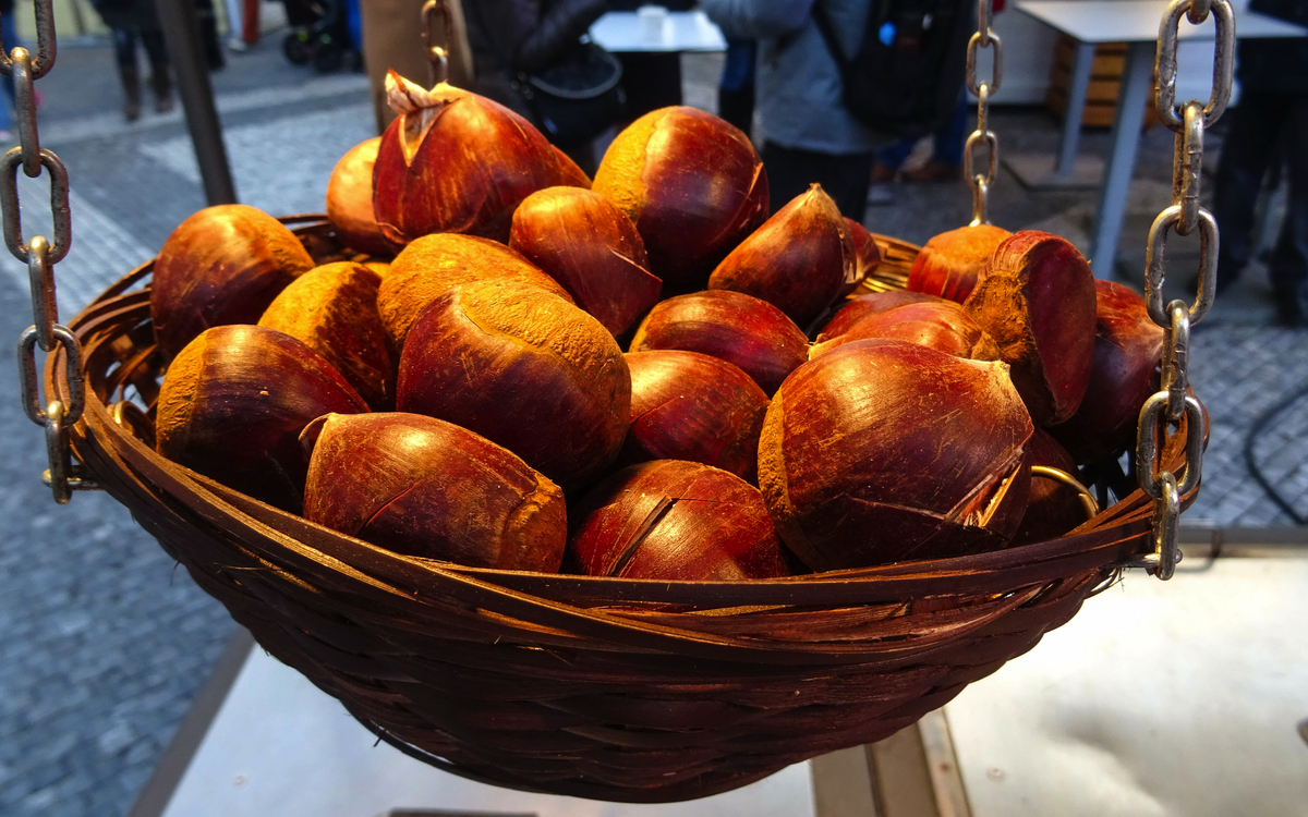 kleiner Korb mit gerösteten Kastanien, die auf dem traditionellen Weihnachtsmarkt auf dem Altstädter Ring verkauft werden, Prag - © Kamila - stock.adobe.com