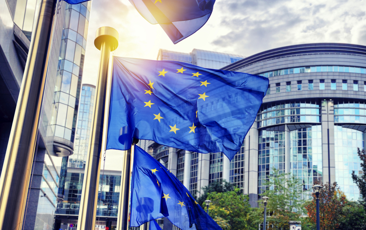 EU-Flaggen wehen vor dem Gebäude des Europäischen Parlaments in Brüssel - © Symbiot - stock.adobe.com