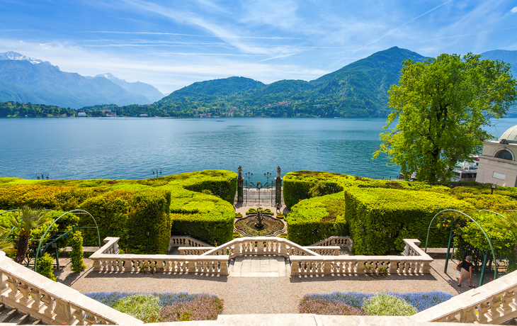 Stadtansicht am See mit Bergen im Hintergrund bei klarem Himmel. - © e55evu - stock.adobe.com