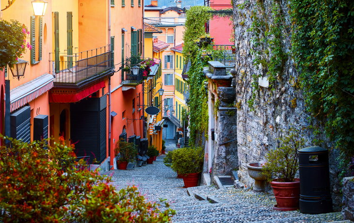 Blick auf einen malerischen See mit Blumen und Bergen im Hintergrund. - © SeaRain - stock.adobe.com