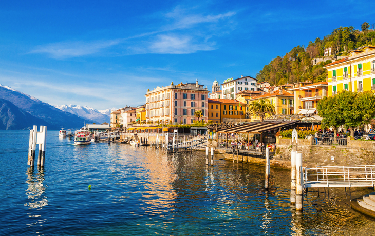 Blick auf einen malerischen See mit Blumen und Bergen im Hintergrund. - © SeaRain - stock.adobe.com