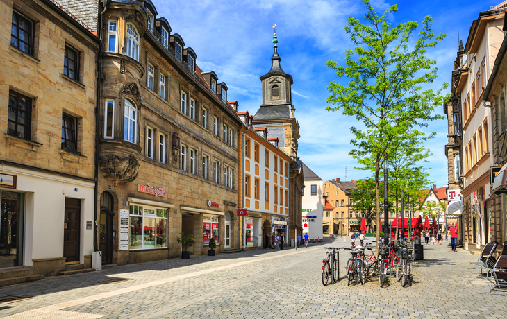 Barockgarten mit Springbrunnen und historischem Gebäude im Hintergrund. - © pure-life-pictures - stock.adobe.com