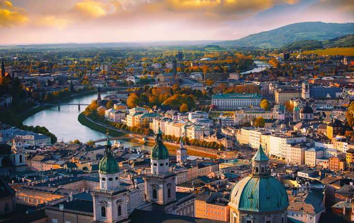 Stadtpanorama mit Fluss, historischen Gebäuden und Hügeln im Hintergrund. - © SASITHORN - stock.adobe.com