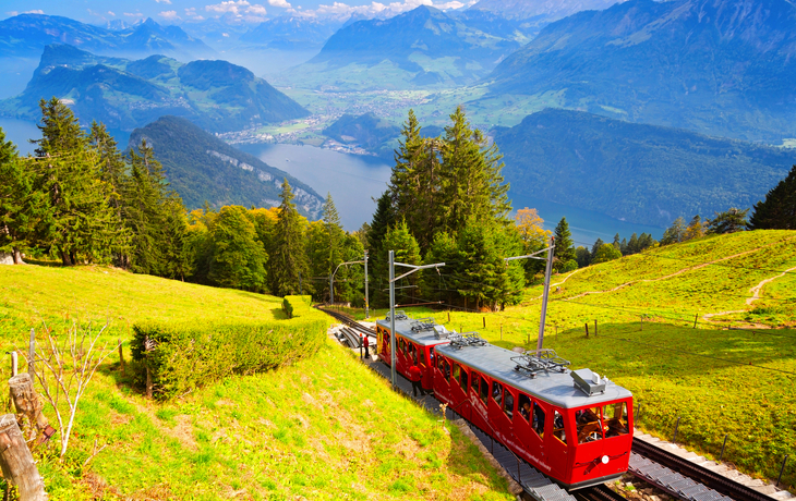 Panoramablick von einem Berg über einen See und eine Stadt bei klarem Himmel. - © djama - stock.adobe.com