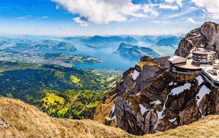 Panoramablick von einem Berg über einen See und eine Stadt bei klarem Himmel. - © djama - stock.adobe.com