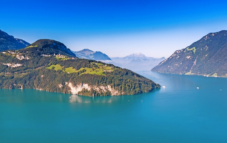 Panoramablick von einem Berg über einen See und eine Stadt bei klarem Himmel. - © djama - stock.adobe.com