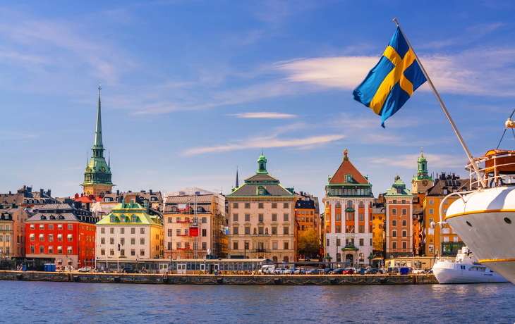 Blick auf Stockholm mit Gebäuden und schwedischer Flagge bei sonnigem Wetter. - © f11photo - stock.adobe.com