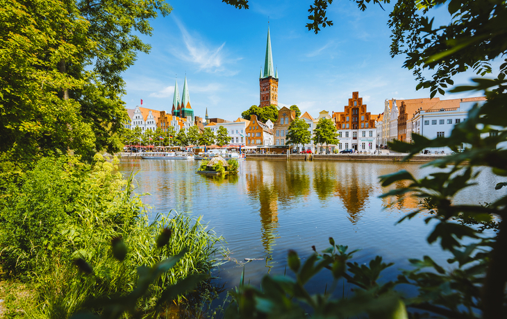 Backstein-Tor mit zwei Türmen, blauer Himmel, Blumen im Vordergrund. - © pure-life-pictures - Fotolia