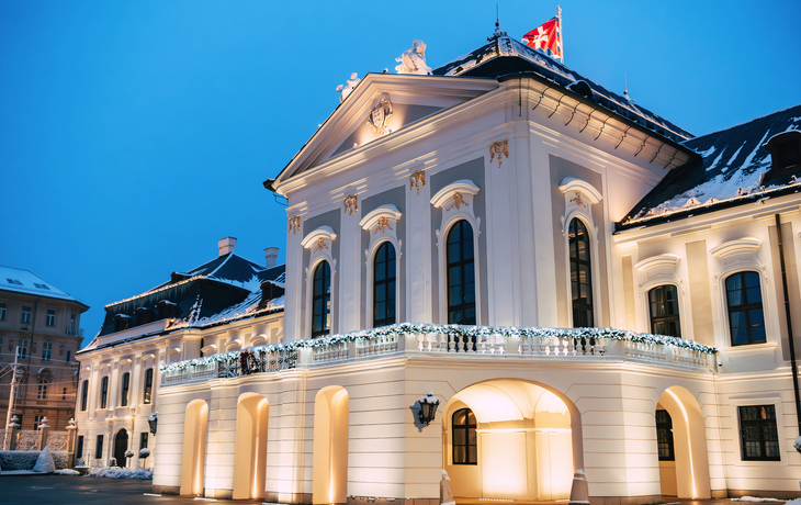 Historisches Gebäude mit Beleuchtung und Schnee darauf bei Dämmerung. - © naszalyg - stock.adobe.com