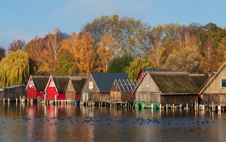 Landschaft mit See, Booten und Ufergebäuden unter bewölktem Himmel. - © Heiko Zahn - stock.adobe.com