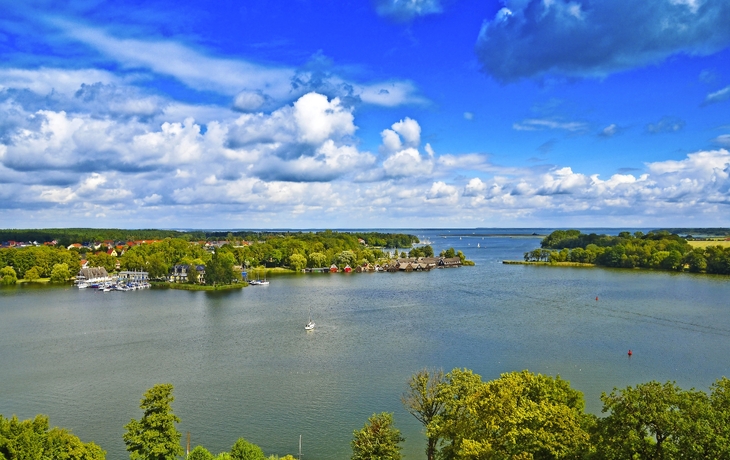 Landschaft mit See, Booten und Ufergebäuden unter bewölktem Himmel. - © Heiko Zahn - stock.adobe.com