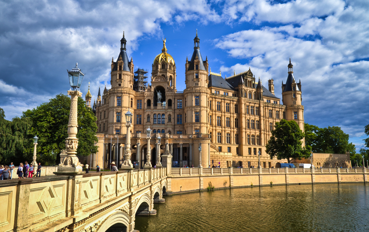 Luftaufnahme eines Schlosses am Wasser unter blauem Himmel und Wolken. - © SEB - www.sebfoto.de - stock.adobe.com