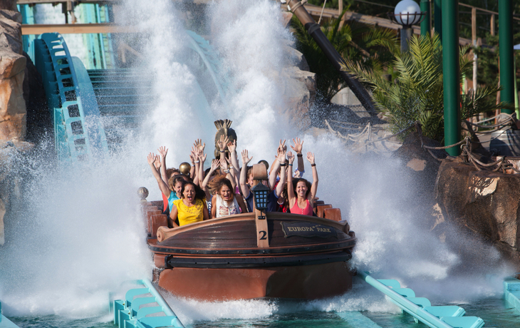 Achterbahn in einem Freizeitpark, voll besetzter Zug, sonniger Tag. - Europa-Park